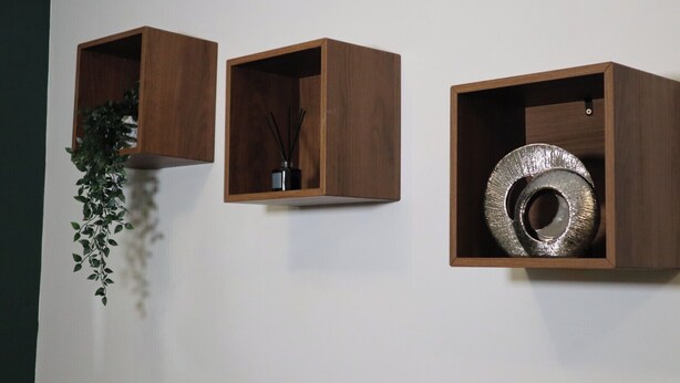 Three wooden wall-mounted shelves with different items: a hanging plant, a black vase with reed sticks, and a metallic circular object. - Luxury Urban Escape Near Nec, Airport, Hs2 (Birmingham)