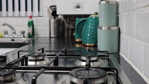 A kitchen with a gas stove, a sink, and a water heater.