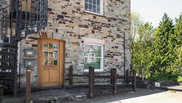 A stone building with a wooden door and a small window.