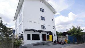 Un immeuble blanc à plusieurs étages, doté d’un toit plat, d’une entrée couverte et d’un numéro « 8 » bien visible sur la façade.