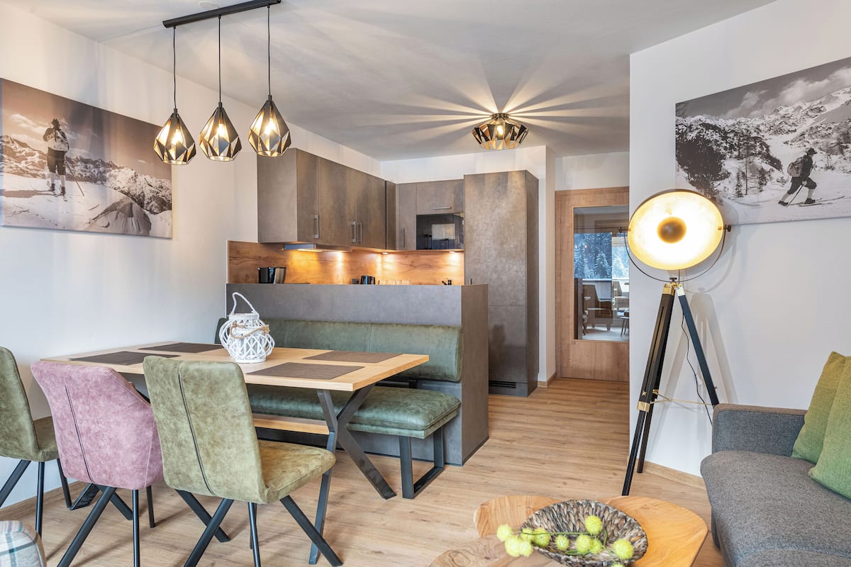 Ein modernes Interieur mit Essbereich, Sitzgelegenheiten und einer großen Stehlampe.