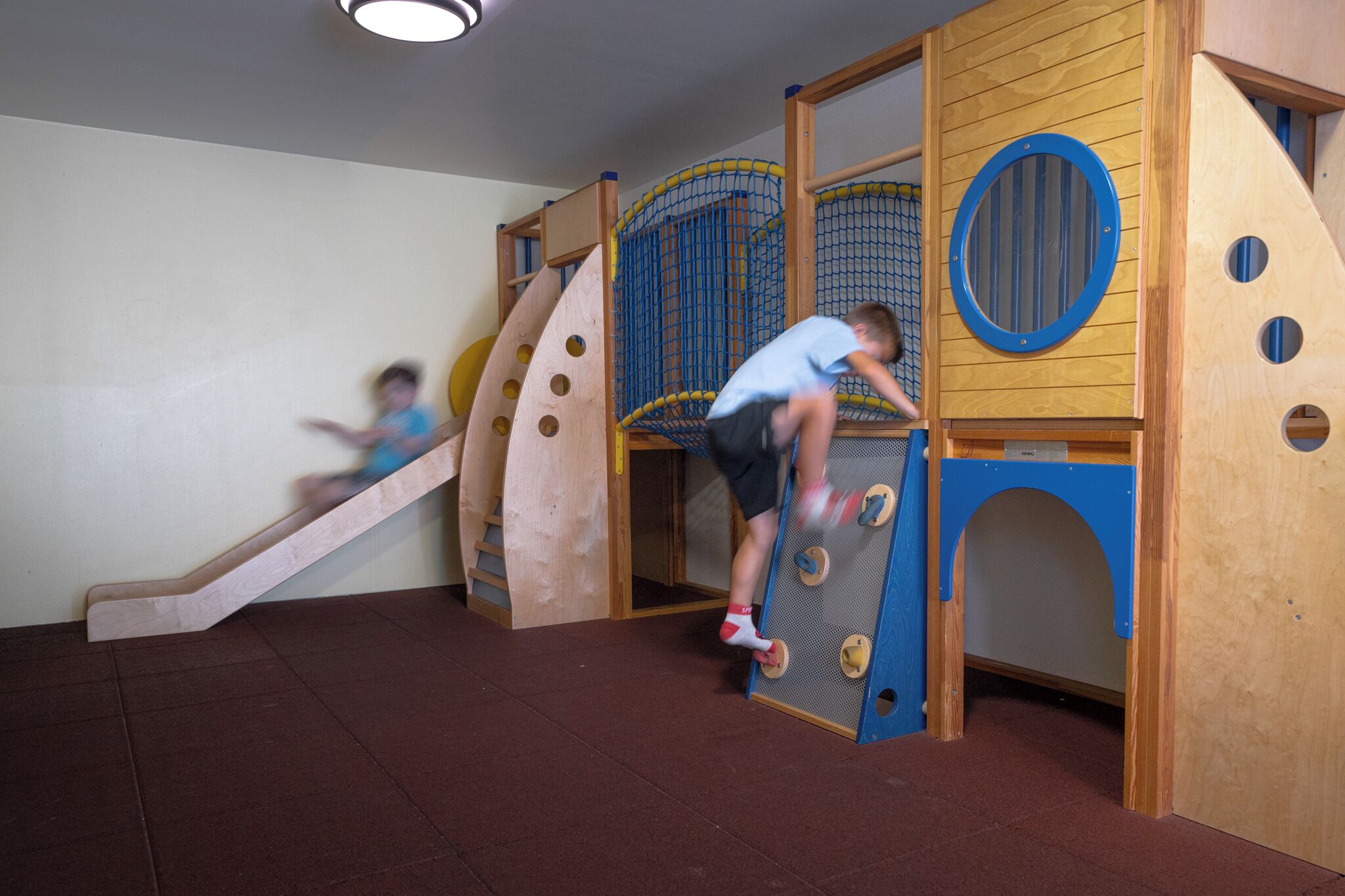 A play area with a wooden slide and climbing structures.