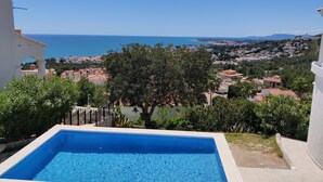 A swimming pool with a clear view of the sea and a town in the background. - Villa with stunning sea view, private pool and garden (Alcocéber)