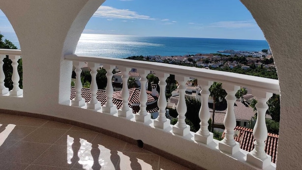 A balcony with white balustrades and a view of the sea and town. - Villa with stunning sea view, private pool and garden (Alcocéber)