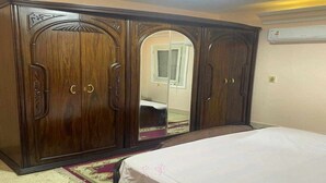 Un dormitorio con un armario grande, una cama y un espejo.