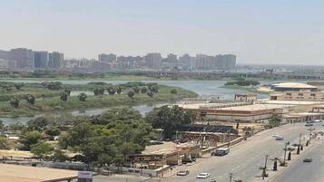 A cityscape with a river, buildings, and a road with vehicles.