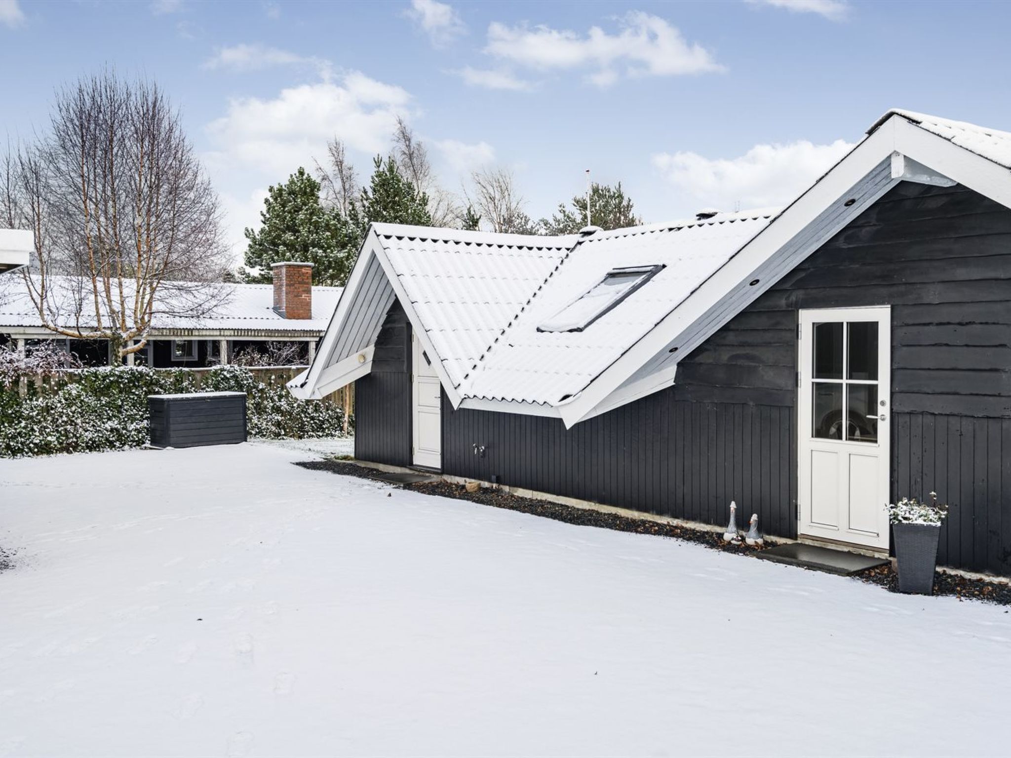 A single-story building with a sloped roof and a skylight.