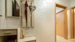 Une salle de bain avec un meuble-lavabo en bois, un miroir et une serviette accrochée au mur.