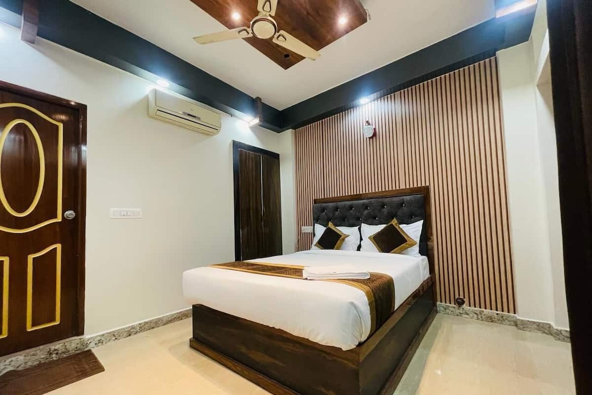 Quarto com uma cama grande, um ventilador de teto e uma porta de madeira.