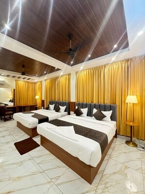 A hotel room with two beds, wooden headboards, marble flooring, and gold curtains. - hotel boss palace (Mysore)