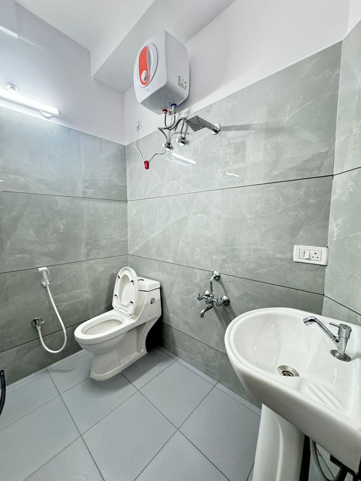 Une salle de bain moderne équipée de toilettes, d’un bidet et d’un lavabo.