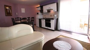 Un espacio habitable pequeño con kitchenette, comedor y sofá.