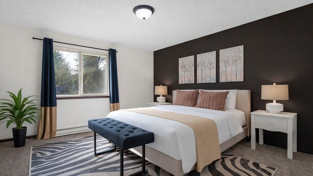 A modern bedroom with a large bed, bedside tables, a bench, a potted plant, and artwork on the wall. - Quiet 2BR/2BA Olympia townhome on acreage near downtown, Capitol, workspace, garage parking (Olympia)