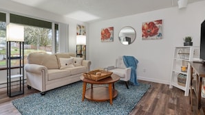 Ein Wohnzimmer mit einer Couch, einem Couchtisch und Kunstwerken an den Wänden.