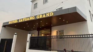 A hotel named "Hotel Satsang Grand" with a modern facade, a covered entrance, and a gated driveway. - Hotel Satsang Grand (Varanasi)