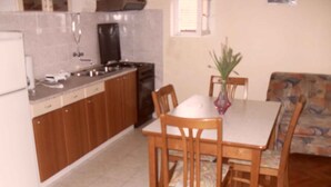 Una cocina compacta con armarios de madera, una mesa de comedor con sillas y un sofá en la sala de estar.