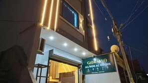 A hotel with a sign for "GARIMA AC/NON AC ROOMS" and a contact number. - Hotel Garima (Ujjain)