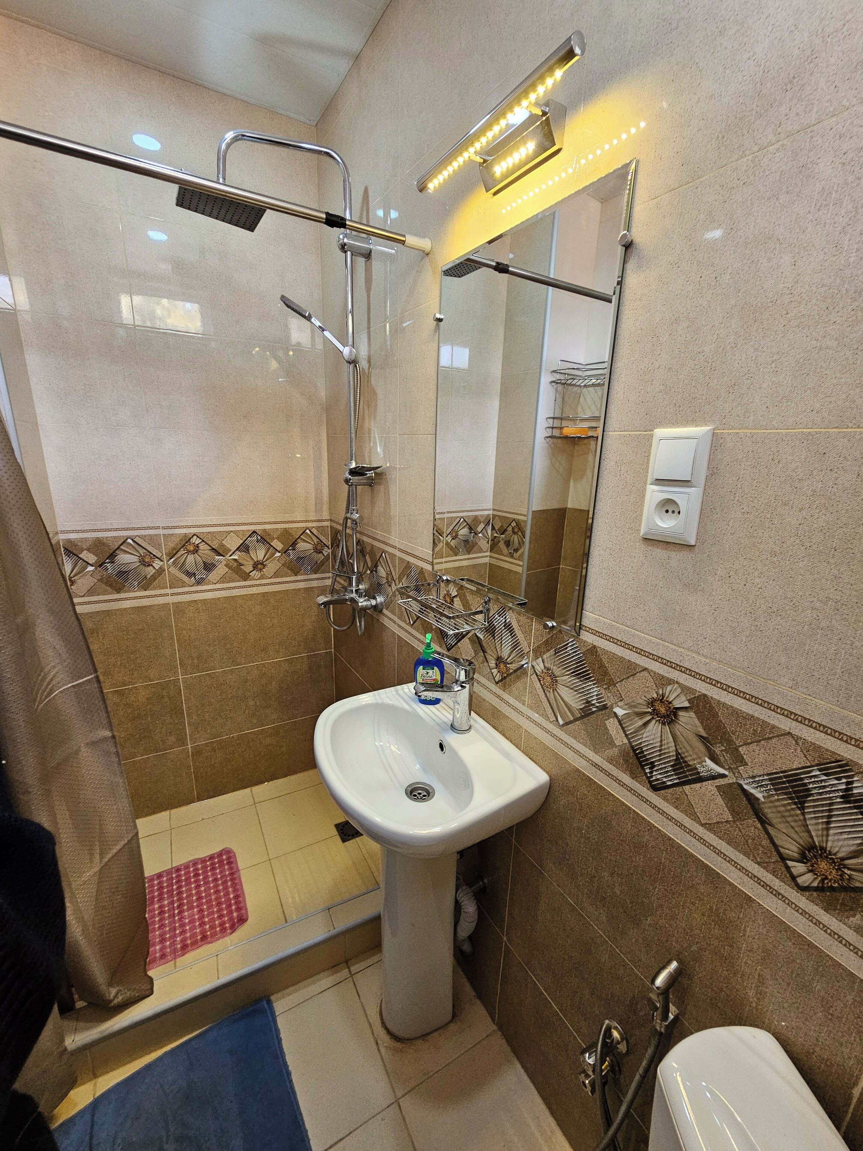Un baño con ducha, lavabo e inodoro.