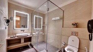 A modern bathroom with a glass-enclosed shower, a large mirror, a toilet, and a sink. - Click Collection Amritsar (Amritsar)
