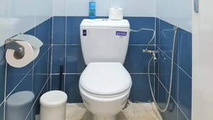 A small, compact bathroom with a toilet, a trash bin, and a shower. - Charming condo in pleasant Rabat with WiFi (Temara)