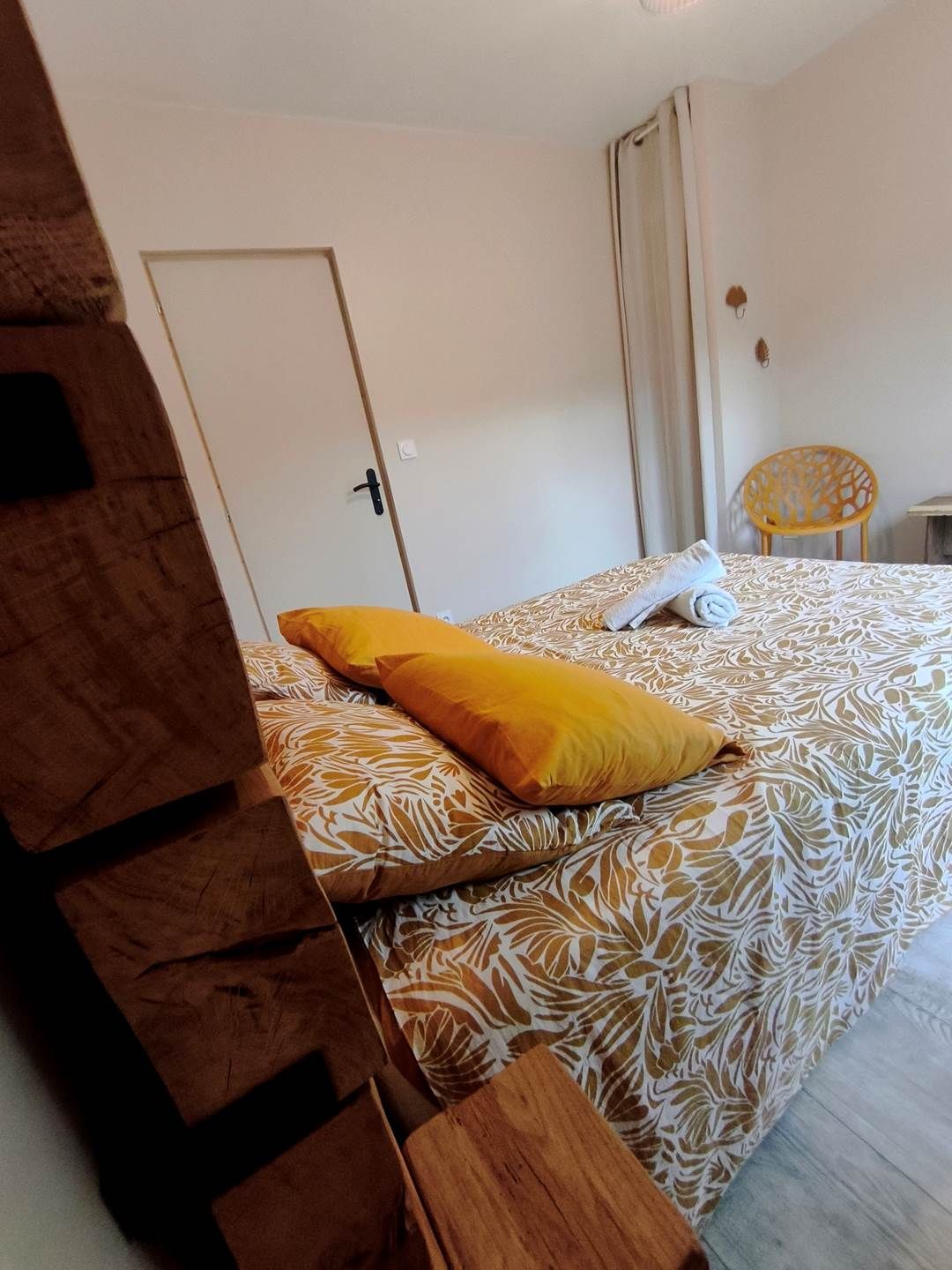 Une chambre d’hôtel avec un lit, une chaise et une porte.