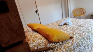 Une chambre d’hôtel avec un lit, une chaise et une porte.