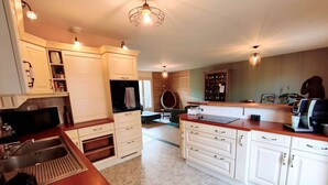 A kitchen with white cabinets, a red countertop, a coffee machine, and a patterned floor. - Room 2: Countryside—Absolutely Peaceful (LINDRY)