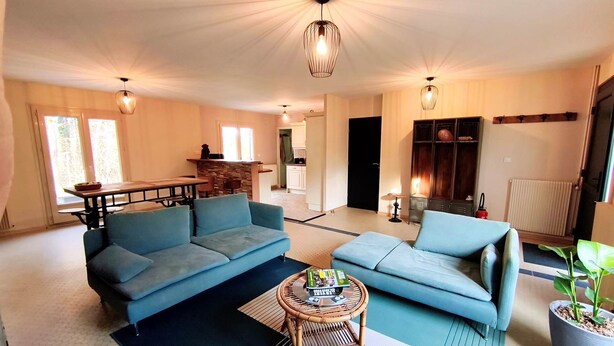 A living room with a sofa, a small round table, and a potted plant. - Room 2: Countryside—Absolutely Peaceful (LINDRY)