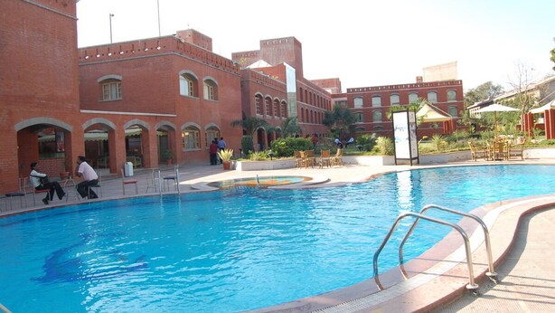 Una piscina con un edificio de ladrillo al fondo.
