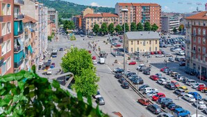 Kerrostalo, jossa on parvekkeita, parkkipaikka ja näkymä kadulle.
