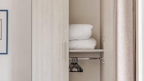 A walk-in closet with a light wood finish, a hanging rack, and neatly folded towels. -  Home Sweet Home (Monreale)
