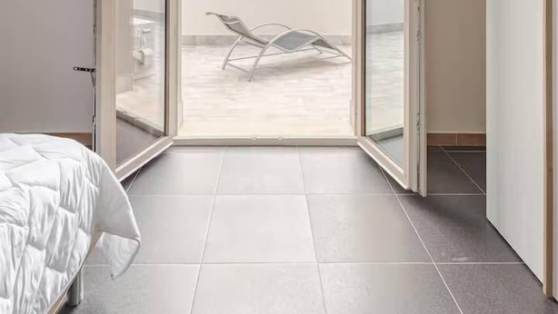 A bedroom with a bed, a sliding glass door leading to a balcony with a chair and a table. -  Home Sweet Home (Monreale)