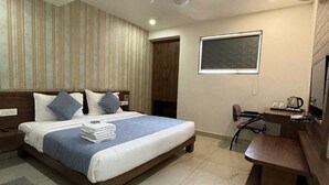 Une chambre d’hôtel moderne, dotée d’un grand lit, d’un bureau et d’une chaise.