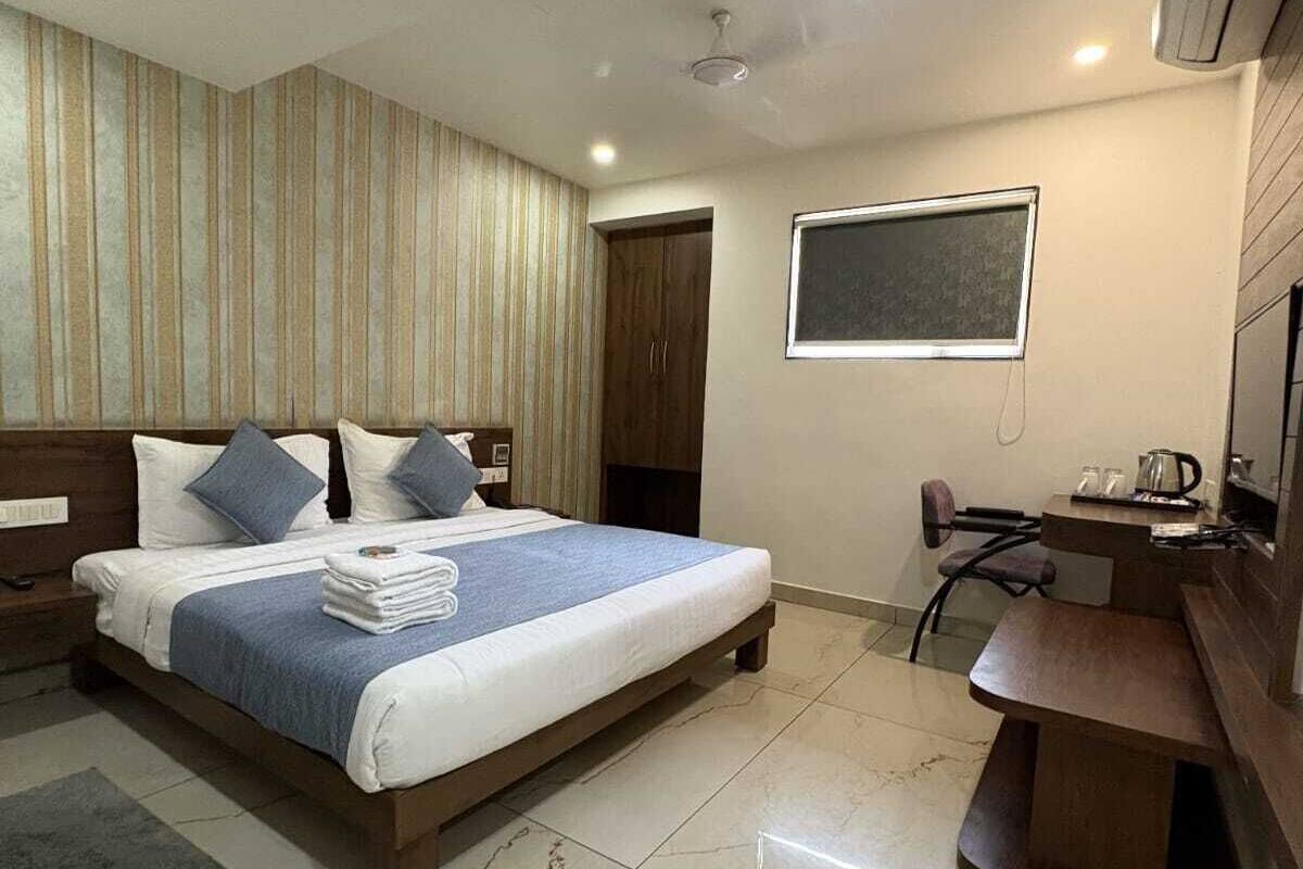 Una habitación de hotel moderna con una cama grande, un escritorio y una silla.