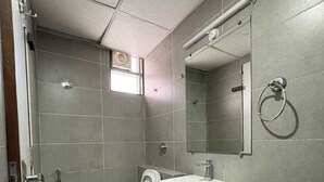 Une salle de bain avec des toilettes, un lavabo et une douche.