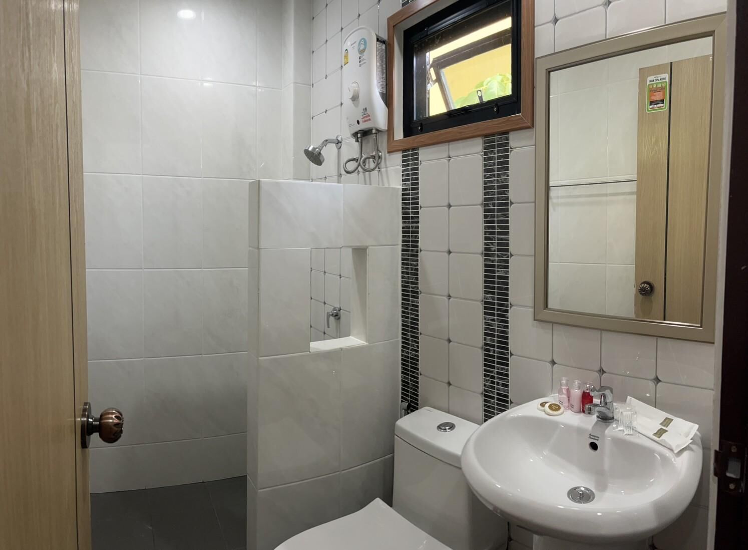 A bathroom with a white sink, mirror, and shower.