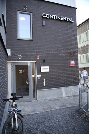 Ein Gebäude mit einem Schild, auf dem „CONTINENTAL“ steht, und einer Tür mit der Aufschrift „23F“.