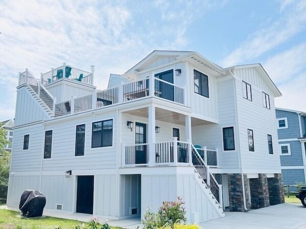 A two-story residential building with a balcony on the upper floor, a covered outdoor area, and a staircase leading to the upper level. - RENOVATED HOME ON THE OCEAN BLOCK! (Bethany Beach)