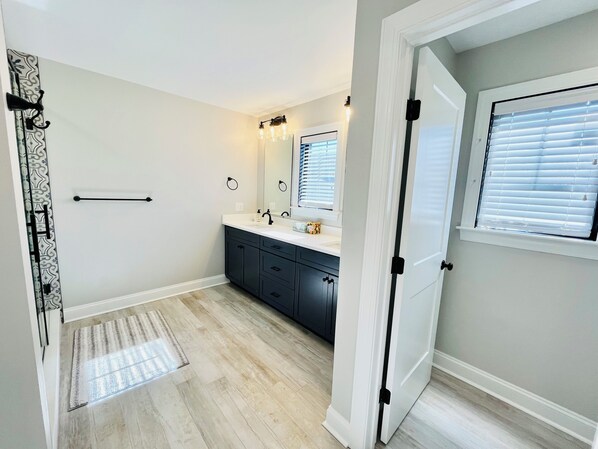 A modern bathroom with a vanity, mirror, and a window with blinds. - RENOVATED HOME ON THE OCEAN BLOCK! (Bethany Beach)
