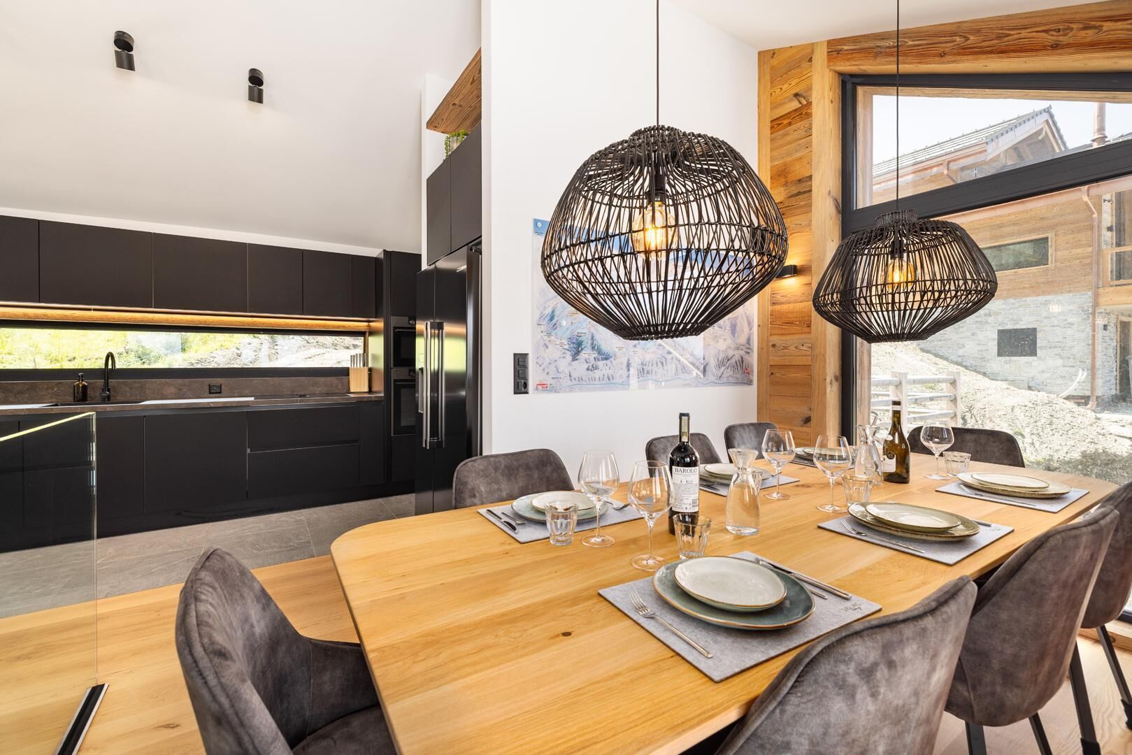 Un espace repas moderne avec une table en bois disposée pour six personnes, entourée de chaises à revêtement gris.