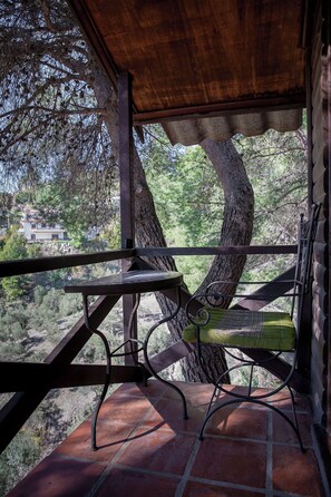 A wooden deck with a metal table and chair, overlooking a mountainous landscape. - Casa Surrender Cómpeta, Casa Surrender Cómpeta (Cómpeta)