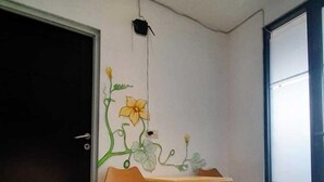 A modern dining area with a table and four chairs, a black door, and a large window. - Malang And Bromo Tour Backpacker (Malang)