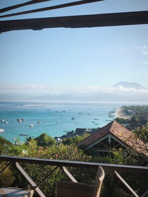 A coastal view with boats, a mountain, and a beach with buildings. - Villa Bagus Lembongan (Lembongan Island)