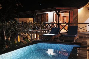 A pool area with lounge chairs and a wooden deck. - Villa Bagus Lembongan (Lembongan Island)
