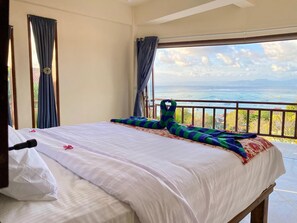 A hotel room with a bed, a view of the sea, and a balcony. - Villa Bagus Lembongan (Lembongan Island)