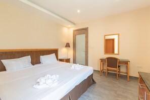 A hotel room with a large bed, a desk, and a chair. - Malta's Gateway (St. Paul's Bay)