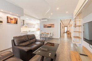 A modern living room with a leather sofa, a coffee table, and a TV on a stand. - Malta's Gateway (St. Paul's Bay)