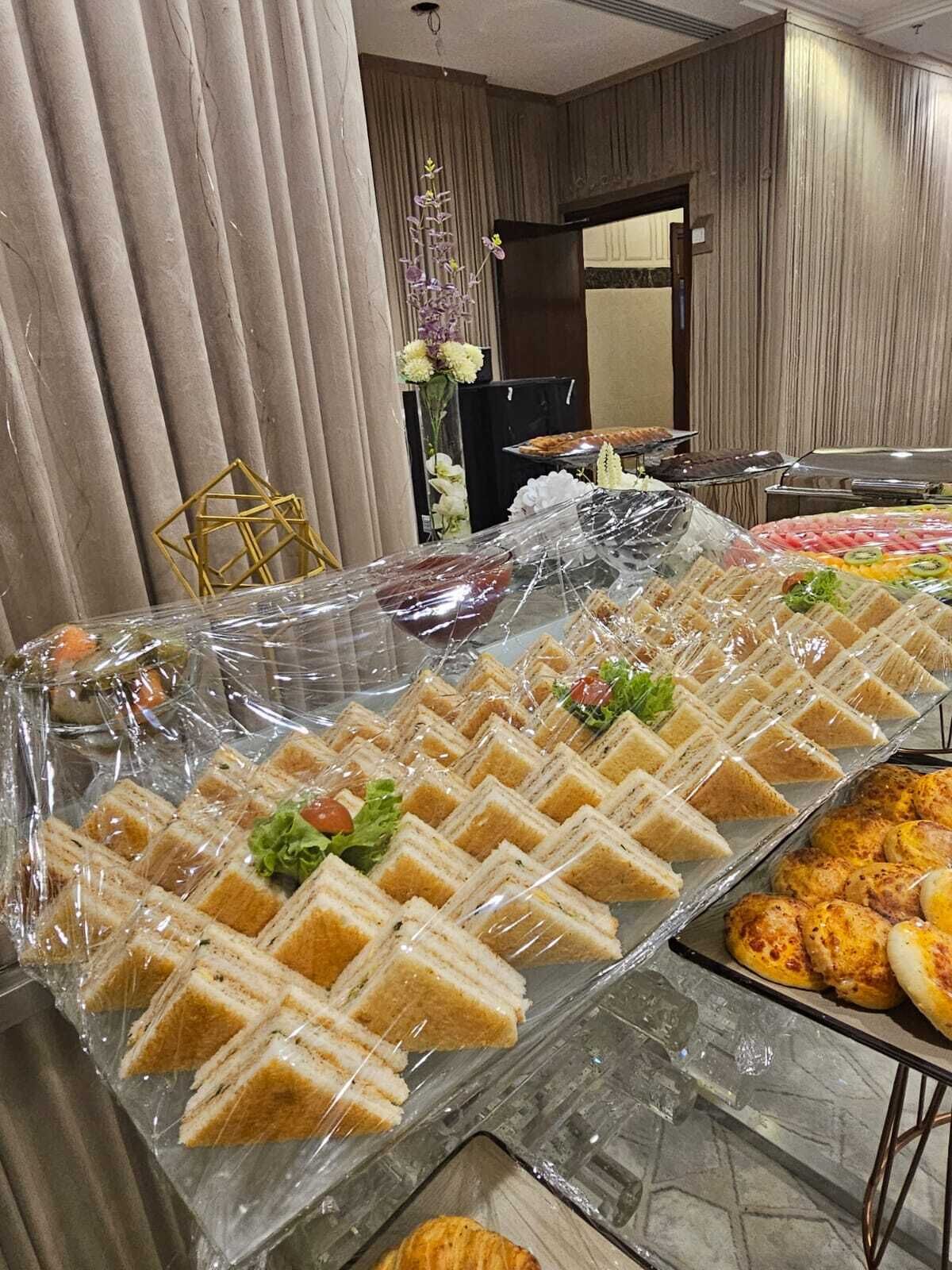 A buffet table with sandwiches, salads, and other food items.