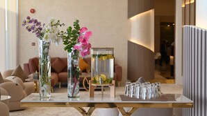 Une table avec des vases de fleurs et un récipient en verre contenant des citrons.