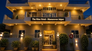 Un hôtel à plusieurs étages, sur lequel on peut lire l’inscription : « The Nine Hotel – Mansarovar Jaipur ».
